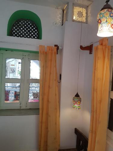 a room with a window with curtains and a lamp at Inn Seventh Heaven in Pushkar