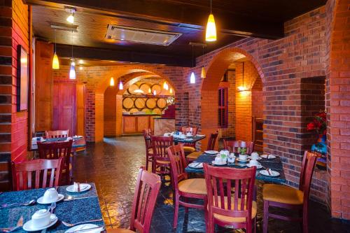 a restaurant with tables and chairs and a brick wall at BON Hotel Empangeni in Empangeni