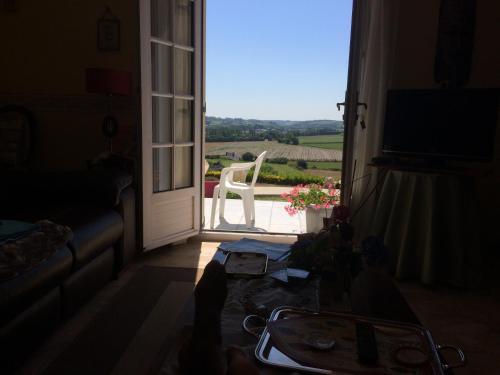 a room with a door open to a patio with a white chair at aux 2 oies in Plouider