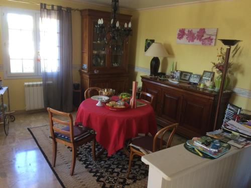 een eetkamer met een tafel met een rode tafelkleed bij aux 2 oies in Plouider