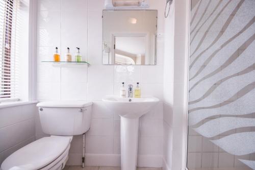 a white bathroom with a toilet and a sink at The Mariners Guest House in Poole