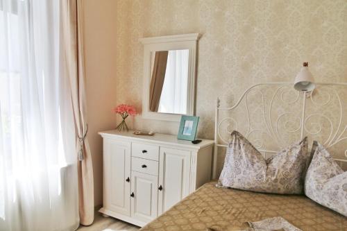 una camera da letto con un letto con specchio e un comò di Adagio Residence a Constanţa