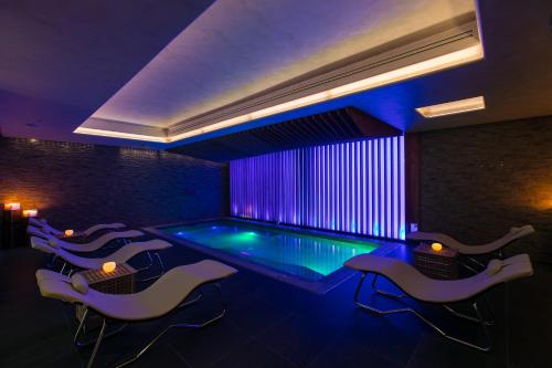 a pool in a room with chairs and a table at Il Podere di Marfisa in Farnese