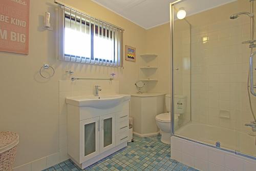 y baño con lavabo, ducha y aseo. en Baltica Beach House, en Culburra Beach