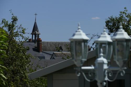 a roof of a house with a church in the background at Le jardin d'Anatole in Bourges