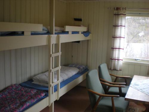Zimmer mit Etagenbetten sowie einem Tisch und Stühlen in der Unterkunft Karalaks in Lakselv