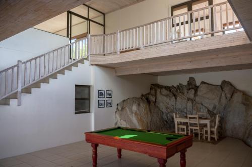 a room with a pool table and a staircase at Barton Luxury Villas in Botrivier
