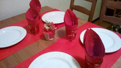 a table with white plates and red napkins on a red table cloth at Stephanie Home in Padova