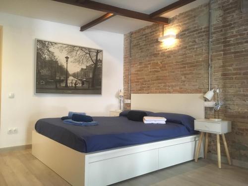 バルセロナにあるSant Josep Oriol, 17のレンガの壁、ベッド付きのベッドルーム1室