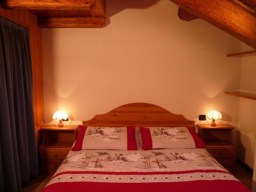 - une chambre avec un lit et deux lampes de chaque côté dans l'établissement Casa Mezzavalle, à Pelugo