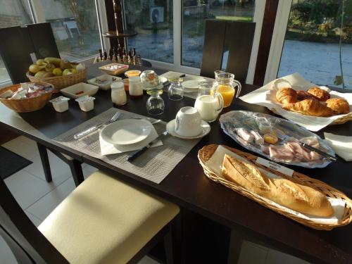 un tavolo con colazione a base di cornetti e uova di La Grange du Verger a Villers-Bretonneux