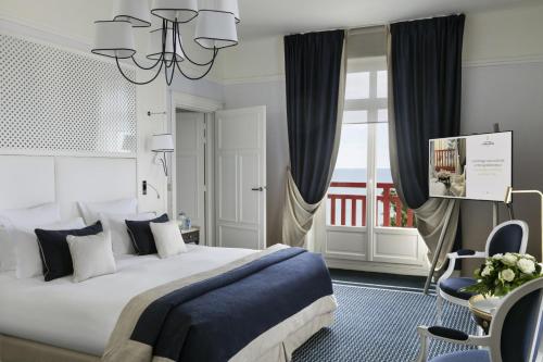 a bedroom with a large bed and a window at Hôtel Barrière L'Hermitage in La Baule