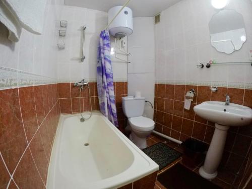 a bathroom with a tub and a toilet and a sink at Asson Hotel Termez in Termiz