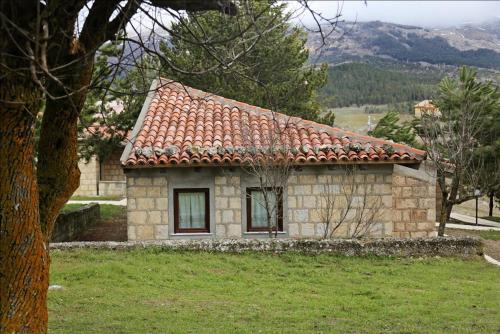 a small stone house with a red roof at Antico Resort Cerasella in Petralia Soprana