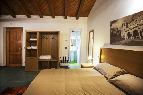 a bedroom with a large bed with a wooden headboard at Antico Resort Cerasella in Petralia Soprana