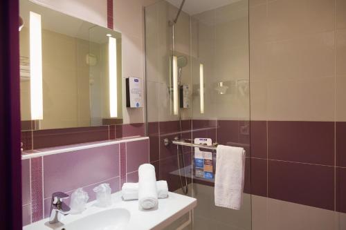 a bathroom with a sink and a mirror at Kyriad Montpellier Sud - A709 in Montpellier