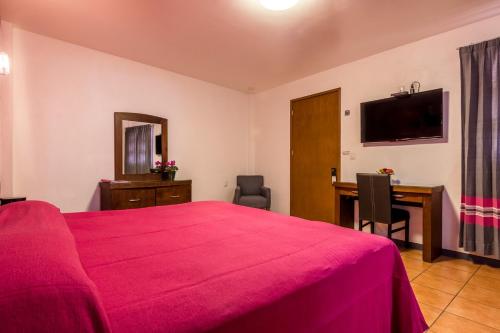 a bedroom with a bed and a desk and a television at Hotel del Marquesado in Oaxaca City