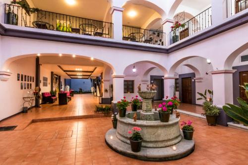 a large hall with a fountain in a building at Hotel del Marquesado in Oaxaca City