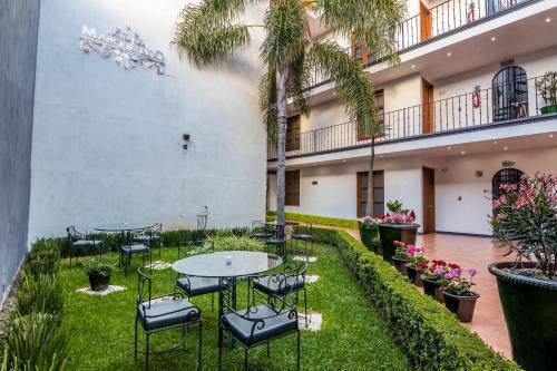 a courtyard with tables and chairs and palm trees at Hotel del Marquesado in Oaxaca City