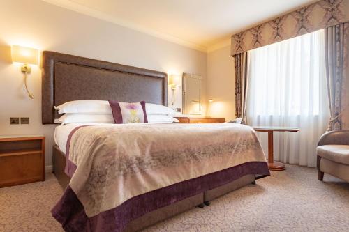 ストラトフォード・アポン・エイボンにあるSwan's Nest Hotelの大きなベッドと窓のあるホテルの部屋