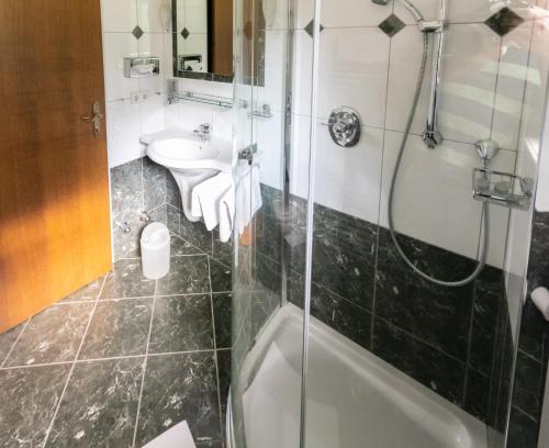 a bathroom with a shower and a sink and a toilet at Pension Bergfried in Grödig