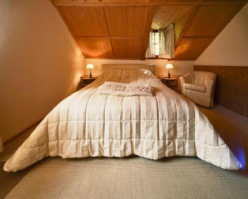 a bedroom with a bed and a chair at Schlosswirt Forst in Lagundo