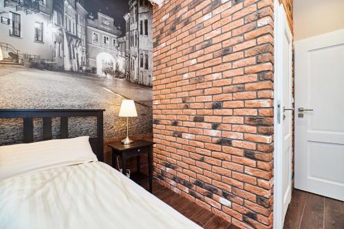 a bedroom with a brick wall and a bed at Carmelito in Lublin