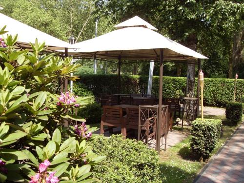 a pavilion with a table and chairs in a garden at Hotel am Stadion in Duisburg