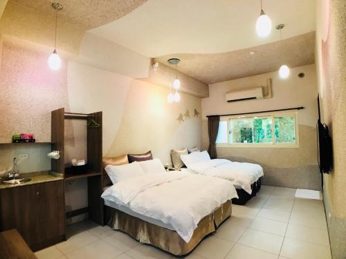 ein Hotelzimmer mit 2 Betten und einem Fenster in der Unterkunft Bi Xuelin in Lugu