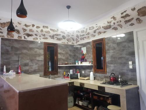 una cucina con bancone e piano di lavoro di maison la branche d oiseaux a Douar Annbirat