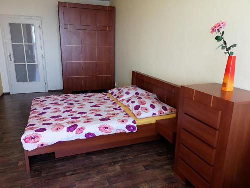 ein Schlafzimmer mit einem Bett und einer Vase mit Blumen darauf in der Unterkunft Apartment High Tatras in Veľký Slavkov