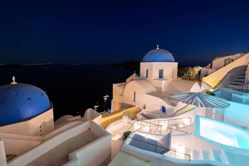 a night view of a building with a church at Cave Suite Oia in Oia
