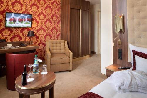 a hotel room with a bed and a table and a chair at Hotel Chemnitzer Hof in Chemnitz