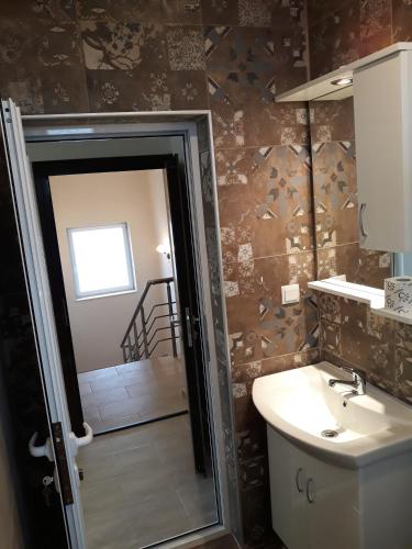 a bathroom with a sink and a shower and a toilet at Vila & Apartments MATEA in Gevgelija