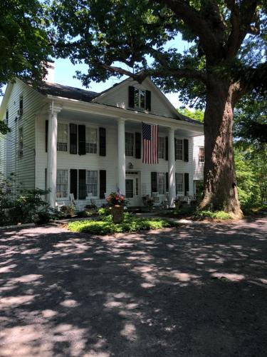 a white house with an american flag on it at Renwick Clifton House B&B in Saugerties