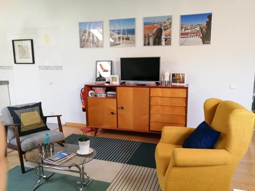 a living room with two chairs and a tv at POMBALINO! Lisbon Concept Apartments in Lisbon