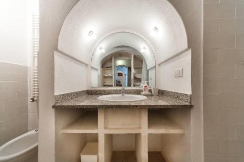 a bathroom with a sink and a mirror at Trulli e Masseria Ianella in Locorotondo