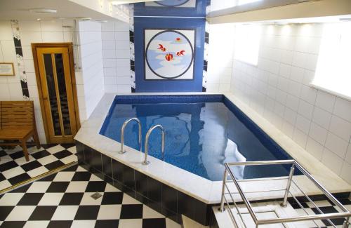 uma banheira de hidromassagem numa casa de banho com piso em xadrez em Respect em Stavropol