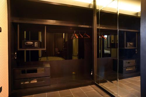 a glass shower in a bathroom with a mirror at Vangohh Eminent Hotel & Spa in Bukit Mertajam