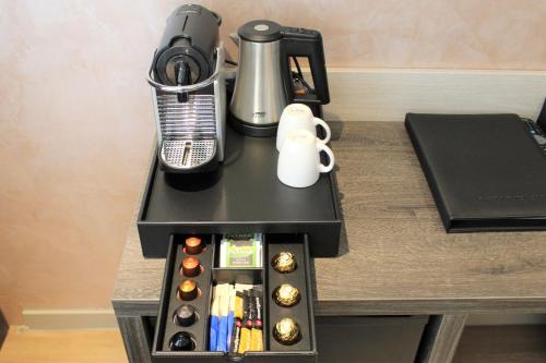 einen Tisch mit Kaffeemaschine und Kaffeemaschine in der Unterkunft Dream Hotel Amsterdam in Amsterdam