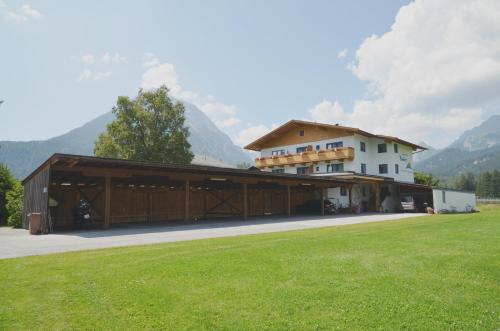 a large building with a grass field in front of it at Apartmenthaus Bader in Leutasch