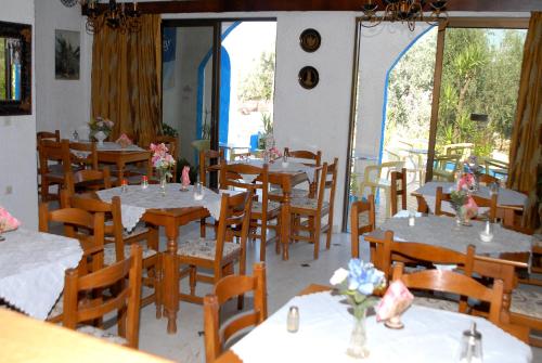 a woman sitting at a table in a restaurant at Anthula Sun in Archangelos