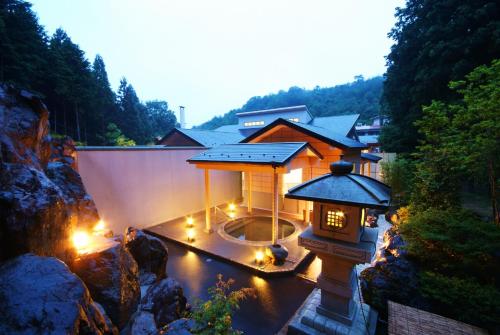 a small house with lights in the water at Shoenso Hozugawatei in Kameoka