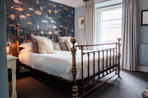 a bedroom with a bed and a wall covered in shells at The Bull Hotel in Bridport