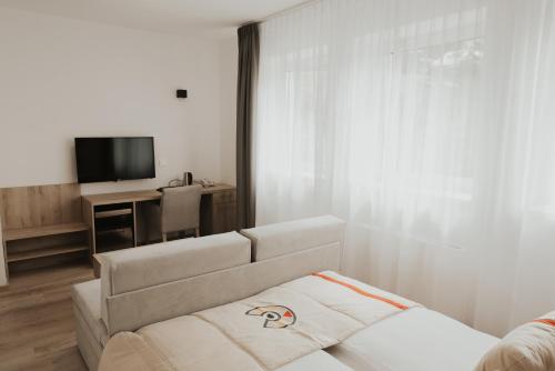a living room with a couch and a television at Aparthotel Centar Sarajevo in Sarajevo