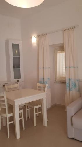 a living room with a table and chairs and a couch at Monolocale II La Maddalena in La Maddalena