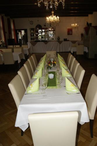 a long table with white chairs and glasses on it at Hotel Mettlacher Hof in Mettlach
