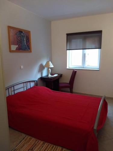 a bedroom with a red bed and a desk at Apartman Tariba in Supetarska Draga