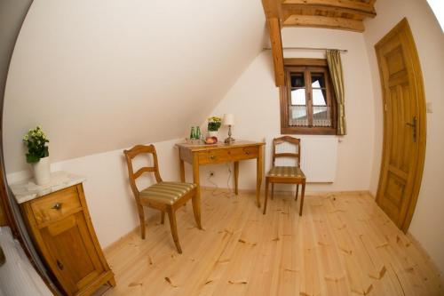 a room with a desk and two chairs and a table at Pensjonat Dom Zegarmistrza in Bogatynia