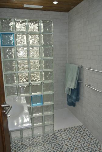 プエルト・デ・ナオスにあるBungalows & Apartamentos Moraniのバスルーム(洗面台、ガラスドア付きのシャワー付)